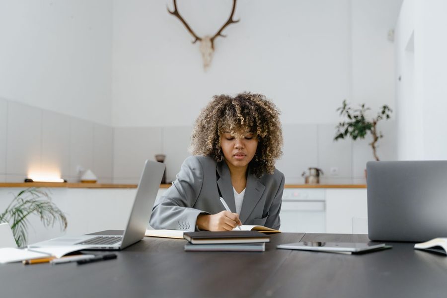 A woman writing a practical plan at her desk.