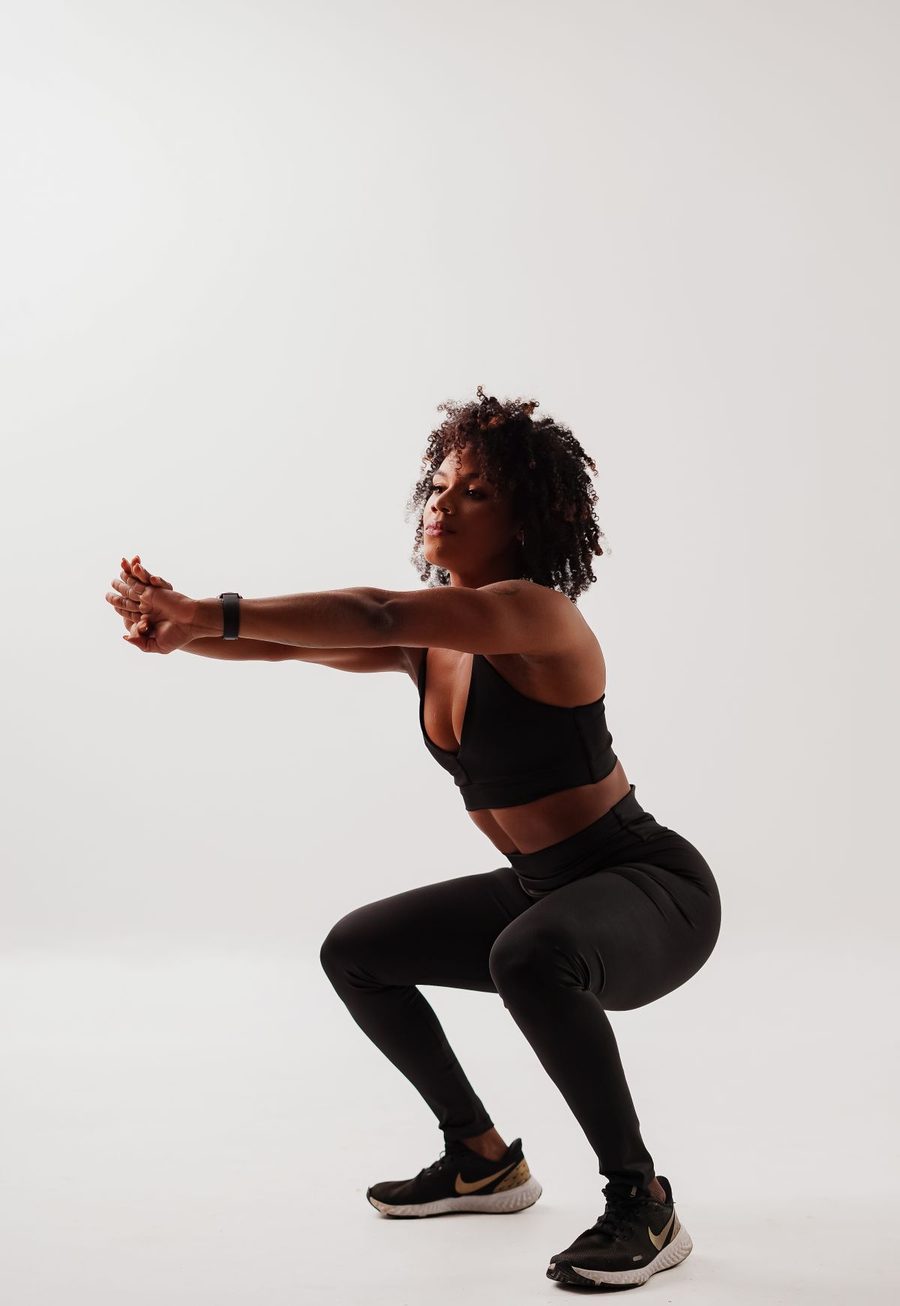A woman performing a squat in activewear.