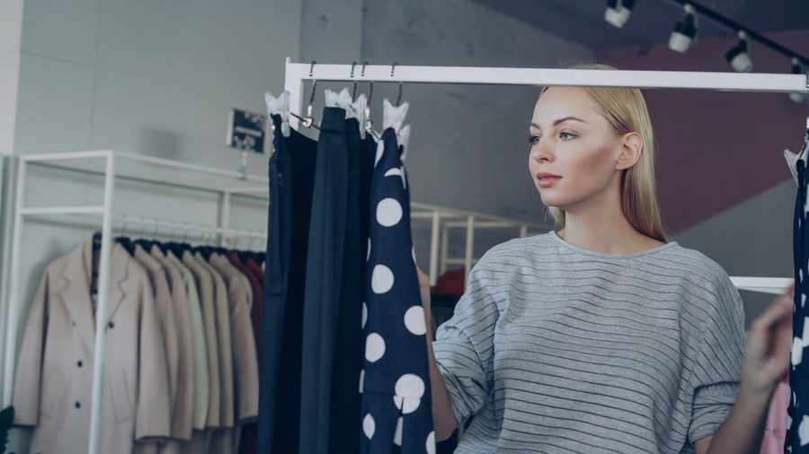 A woman browsing clothing before deciding what to buy.