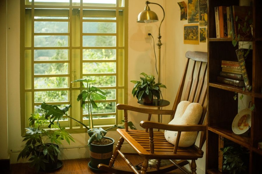 A cozy home reading corner with a chair, books and plants.