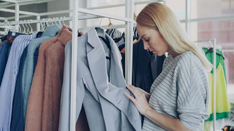 A woman browsing everyday clothes in a wardrobe.