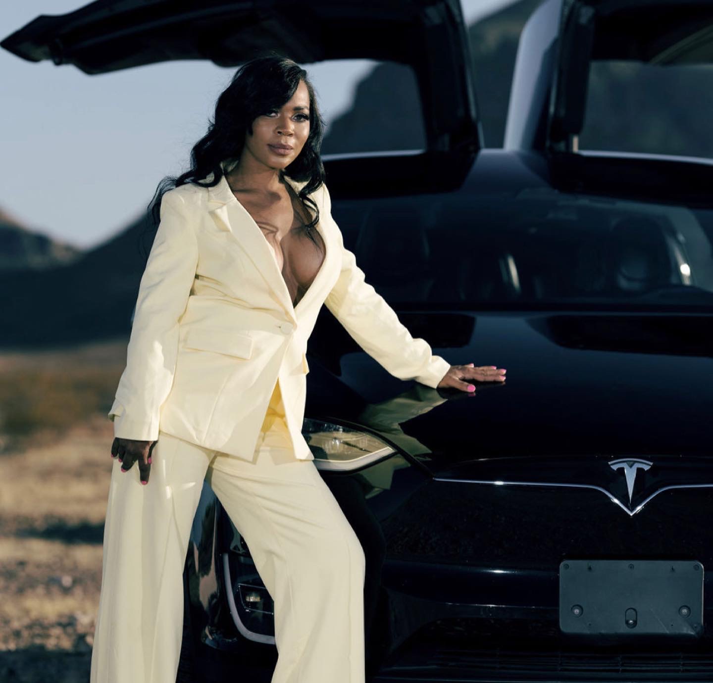 Nikki smiling in a cream suit