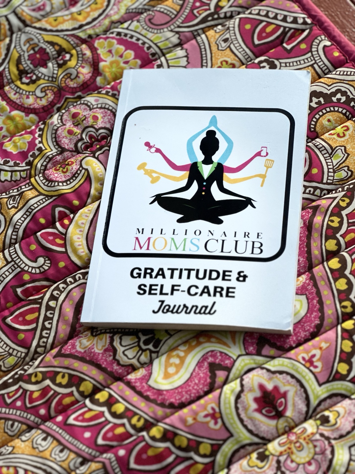 Nikki holding the Gratitude and Self-Care Journal at the beach