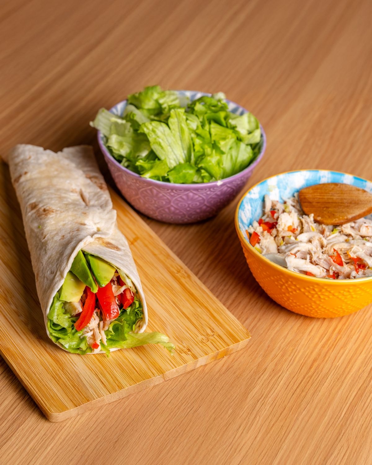 Chicken wrap with greens and chickpeas on a wooden board